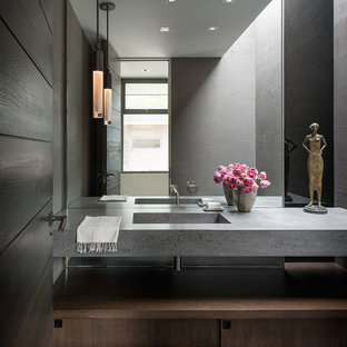 Ispirazione per un bagno di servizio minimalista con ante lisce, ante in legno bruno, pareti grigie, parquet scuro, lavabo integrato, pavimento marrone e top grigio