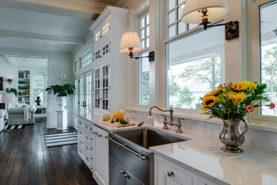 Eat-in kitchen - mid-sized transitional medium tone wood floor and brown floor eat-in kitchen idea with a farmhouse sink, glass-front cabinets, white cabinets, marble countertops and stainless steel appliances
