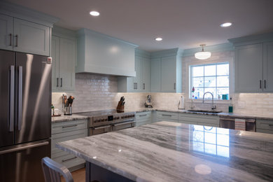 Kitchen - mid-sized modern kitchen idea in Detroit with an undermount sink, flat-panel cabinets, granite countertops, white backsplash, ceramic backsplash, stainless steel appliances and an island