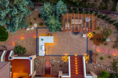Mid-sized minimalist backyard concrete paver patio kitchen photo in Denver with a pergola