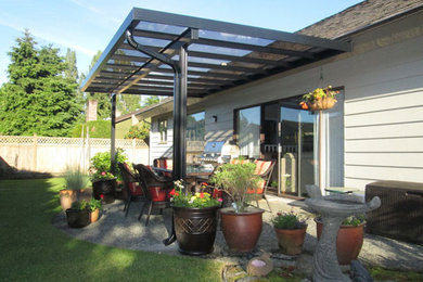 This is an example of a mid-sized backyard patio in Vancouver with concrete slab and an awning.