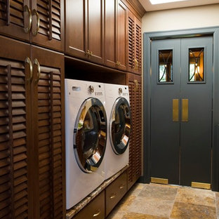 Traditional separated utility room in Other with louvered cabinets, dark wood cabinets and a side by side washer and dryer.