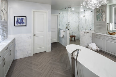 Example of a large transitional master gray tile and white tile medium tone wood floor bathroom design in Dallas with raised-panel cabinets, white cabinets, a one-piece toilet, gray walls, an undermount sink and marble countertops