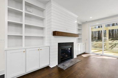 Mid-sized elegant open concept medium tone wood floor and brown floor living room photo in Raleigh with white walls, a standard fireplace, a shiplap fireplace and a wall-mounted tv