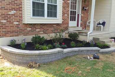 Design ideas for a mid-sized traditional drought-tolerant and partial sun front yard brick retaining wall landscape in Philadelphia.