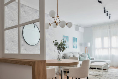 Foto de salón abierto y gris y blanco escandinavo pequeño con paredes blancas, suelo laminado, suelo marrón, papel pintado y cortinas