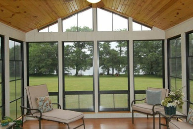 This is an example of a mid-sized modern sunroom in Kansas City with light hardwood floors, no fireplace, a standard ceiling and brown floor.