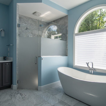 Traditional master bath utilizing frosted and clear glass to allow for needed pr