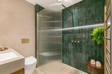 Design ideas for a small contemporary shower room bathroom in London with flat-panel cabinets, medium wood cabinets, a walk-in shower, a wall mounted toilet, green tiles, ceramic tiles, beige walls, ceramic flooring, a built-in sink, solid surface worktops, beige floors, beige worktops, a wall niche, a single sink and a built in vanity unit.
