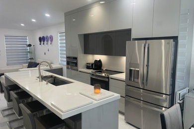 Inspiration for a small modern single-wall porcelain tile and white floor eat-in kitchen remodel in Miami with an undermount sink, flat-panel cabinets, gray cabinets, quartz countertops, white backsplash, quartz backsplash, stainless steel appliances, an island and white countertops