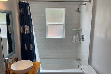 Small ceramic tile and white floor tub/shower combo photo with white walls