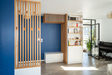 Cette image montre un grand hall d'entrée design avec un mur bleu, parquet foncé et une porte simple.