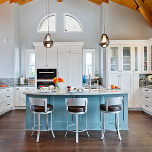 サンディエゴの巨大なビーチスタイルのおしゃれなキッチン (エプロンフロントシンク、シェーカースタイル扉のキャビネット、ソープストーンカウンター、マルチカラーのキッチンパネル、ガラスタイルのキッチンパネル、シルバーの調理設備、濃色無垢フローリング、白いキャビネット) の写真