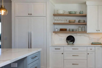 Kitchen - large galley brown floor kitchen idea in Los Angeles with shaker cabinets, white cabinets, marble countertops, white backsplash, subway tile backsplash, an island and white countertops