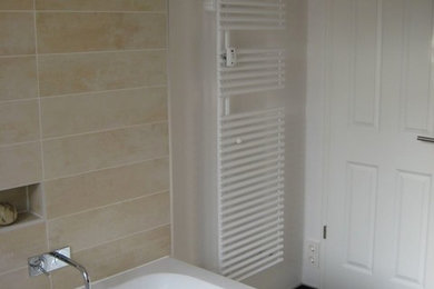 Kleines Klassisches Badezimmer En Suite mit flächenbündigen Schrankfronten, dunklen Holzschränken, Einbaubadewanne, bodengleicher Dusche, Wandtoilette, beigen Fliesen, weißer Wandfarbe, integriertem Waschbecken und Mineralwerkstoff-Waschtisch in Berlin