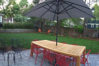 Design ideas for a mid-sized transitional backyard patio in Providence with concrete pavers.