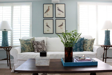 This is an example of a mid-sized beach style enclosed living room in Jacksonville with blue walls, porcelain floors, no fireplace and a wall-mounted tv.