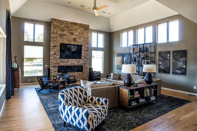 Living room - large transitional open concept light wood floor living room idea in Other with gray walls, a hanging fireplace, a stone fireplace and a wall-mounted tv