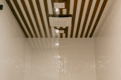オースティンにあるお手頃価格の中くらいなミッドセンチュリースタイルのおしゃれなマスターバスルーム (テラゾーの床、クオーツストーンの洗面台、洗面台2つ、独立型洗面台、板張り天井) の写真