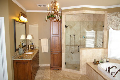 Large transitional master bathroom in Atlanta with an undermount sink, raised-panel cabinets, medium wood cabinets, granite benchtops, a drop-in tub, a corner shower, a two-piece toilet, beige tile, porcelain tile, beige walls, porcelain floors, beige floor and a hinged shower door.