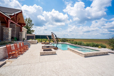 Mid-sized southwest backyard stamped concrete and rectangular hot tub photo in Houston