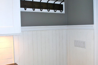 Example of a small transitional slate floor entryway design in New York with gray walls and a glass front door