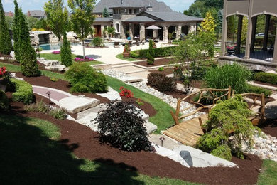 Design ideas for an expansive contemporary backyard partial sun garden for summer in Detroit with mulch.