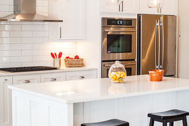 Kitchen - transitional kitchen idea in Minneapolis with white cabinets, white backsplash, subway tile backsplash and an island