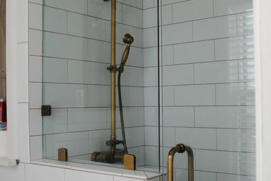 Mid-sized 1950s master ceramic tile and white tile ceramic tile and gray floor bathroom photo in Kansas City with a wall-mount sink, recessed-panel cabinets, gray cabinets, a one-piece toilet, white walls, granite countertops and white countertops