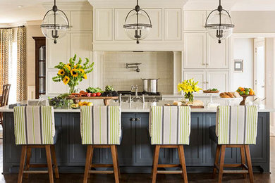 Open concept kitchen - mid-sized transitional u-shaped medium tone wood floor open concept kitchen idea in Little Rock with a farmhouse sink, beaded inset cabinets, white cabinets, quartz countertops, white backsplash, subway tile backsplash, stainless steel appliances and an island