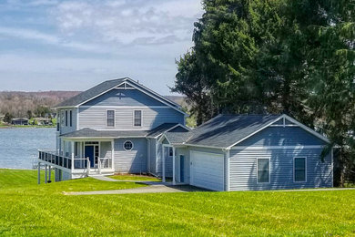 Mid-sized beach style blue two-story vinyl exterior home photo in Other with a shingle roof