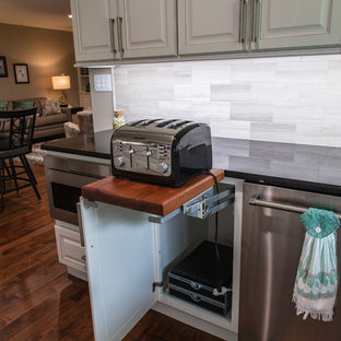 Пример оригинального дизайна: большая параллельная кухня в стиле современная классика с кладовкой, врезной раковиной, фасадами с выступающей филенкой, белыми фасадами, столешницей из кварцита, разноцветным фартуком, фартуком из известняка, техникой из нержавеющей стали, паркетным полом среднего тона, островом и коричневым полом