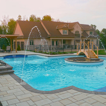 Pool with a firepit by Exact Landscapes