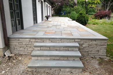 Inspiration for a large traditional front yard patio in Minneapolis with natural stone pavers.
