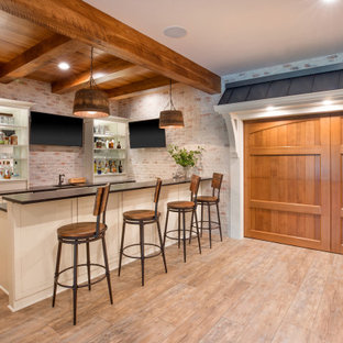Idées déco pour un grand sous-sol campagne semi-enterré avec un bar de salon, un sol en vinyl, une cheminée standard, un manteau de cheminée en pierre, un plafond en lambris de bois et un mur en parement de brique.