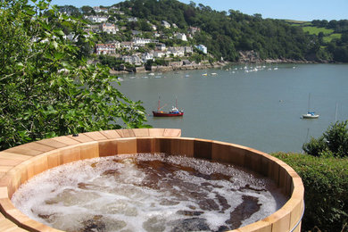 Inspiration for a mid-sized rustic backyard aboveground hot tub remodel in Orange County