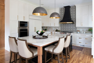 Inspiration for a mid-sized transitional u-shaped medium tone wood floor and brown floor eat-in kitchen remodel in Minneapolis with shaker cabinets, white cabinets, multicolored backsplash, mosaic tile backsplash, colored appliances, an island, white countertops and an undermount sink