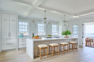 Large single-wall light wood floor, beige floor and coffered ceiling open concept kitchen photo in New York with an undermount sink, shaker cabinets, white cabinets, marble countertops, white backsplash, ceramic backsplash, paneled appliances, an island and white countertops