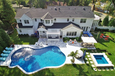 Hot tub - huge contemporary backyard stone and custom-shaped natural hot tub idea in New York