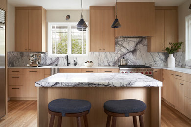 Example of a minimalist eat-in kitchen design in San Francisco with light wood cabinets, marble countertops, multicolored backsplash, marble backsplash, stainless steel appliances, an island and multicolored countertops
