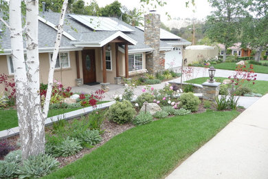 This is an example of a mid-sized traditional front yard full sun xeriscape in Los Angeles with natural stone pavers.