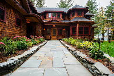 Example of a mountain style brown two-story wood exterior home design in Burlington with a hip roof