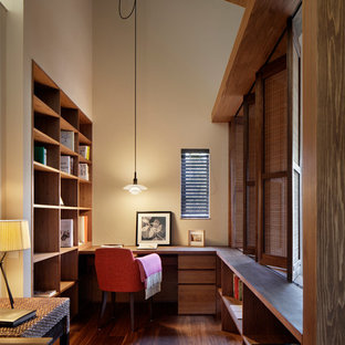 This is an example of a midcentury study in Fukuoka with white walls, dark hardwood flooring and a built-in desk.