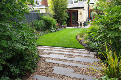 Medium sized contemporary back xeriscape partial sun garden in Cambridgeshire with a garden path and decorative stones.