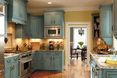Enclosed kitchen - mid-sized traditional u-shaped dark wood floor and brown floor enclosed kitchen idea in Orange County with a double-bowl sink, recessed-panel cabinets, blue cabinets, granite countertops, beige backsplash, stone tile backsplash, stainless steel appliances and no island