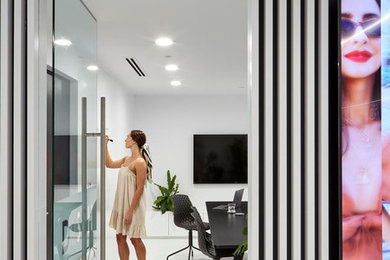 This is an example of a large contemporary home studio in Brisbane with white walls, a freestanding desk and white floor.