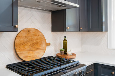 Inspiration for a mid-sized transitional u-shaped medium tone wood floor and brown floor eat-in kitchen remodel in Seattle with a drop-in sink, shaker cabinets, blue cabinets, solid surface countertops, white backsplash, porcelain backsplash, stainless steel appliances, an island and white countertops