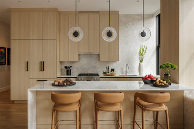 Open concept kitchen - large contemporary u-shaped light wood floor and beige floor open concept kitchen idea in New York with an integrated sink, flat-panel cabinets, beige cabinets, quartz countertops, white backsplash, quartz backsplash, paneled appliances, an island and white countertops