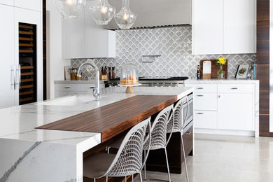 Inspiration for a mid-sized modern limestone floor and gray floor kitchen remodel in San Diego with an undermount sink, flat-panel cabinets, white cabinets, quartz countertops, multicolored backsplash, glass tile backsplash, paneled appliances, an island and white countertops