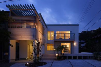 Photo of a contemporary two-storey stucco white exterior in Tokyo Suburbs with a shed roof.